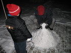 晚上九点，北京初降雪，小罕和爸爸在花园内堆雪人